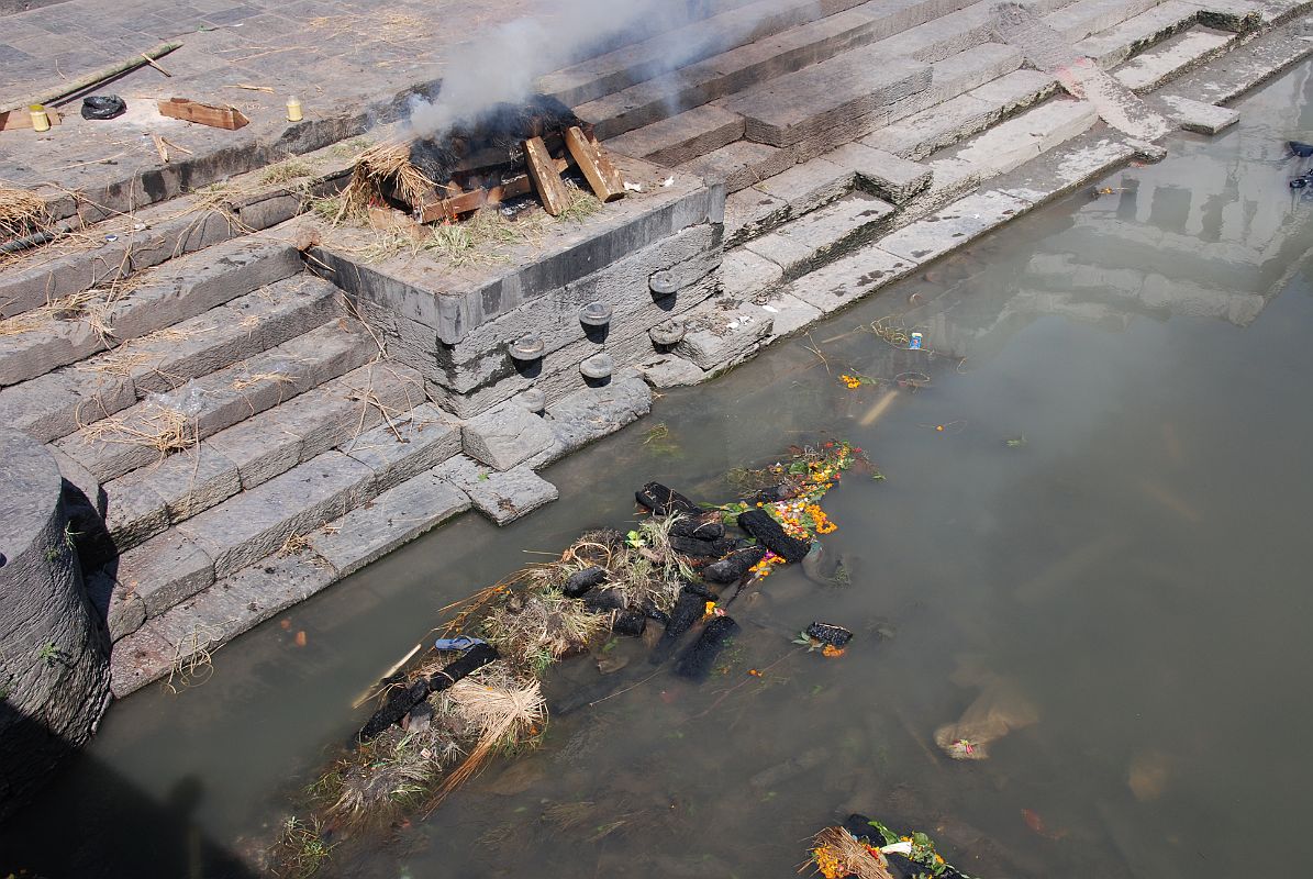 Kathmandu Pashupatinath 10 Burning Ghat At Edge of River The wood and what�s left of the burned body are dumped into the Bagmati River after the cremation at Pashupatinath in Kathmandu is over.